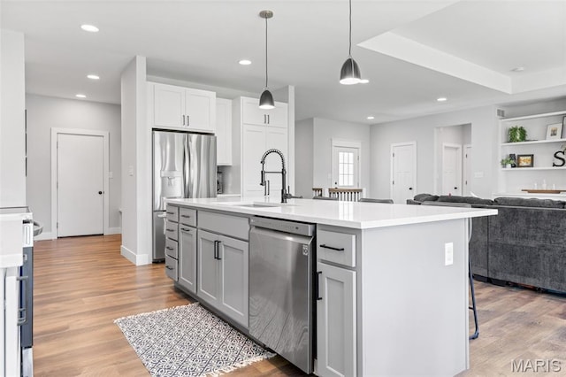 10523 Village Ln, Foristell, MO 63348 - kitchen with stainless steel appliances, open floor plan, light countertops, light wood-type flooring, and recessed lighting