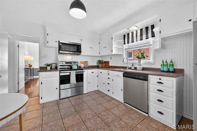 5021 Hi View Ave, Shrewsbury, MO 63119 - kitchen with appliances with stainless steel finishes, dark countertops, open shelves, white cabinetry, and tile patterned flooring
