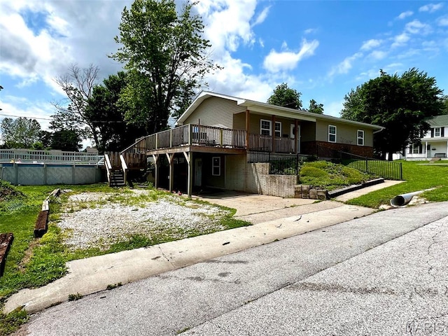320 N Dickerson St, Palmyra, MO 63461 - view of front of home with concrete driveway, a wooden deck, an outdoor pool, and stairs