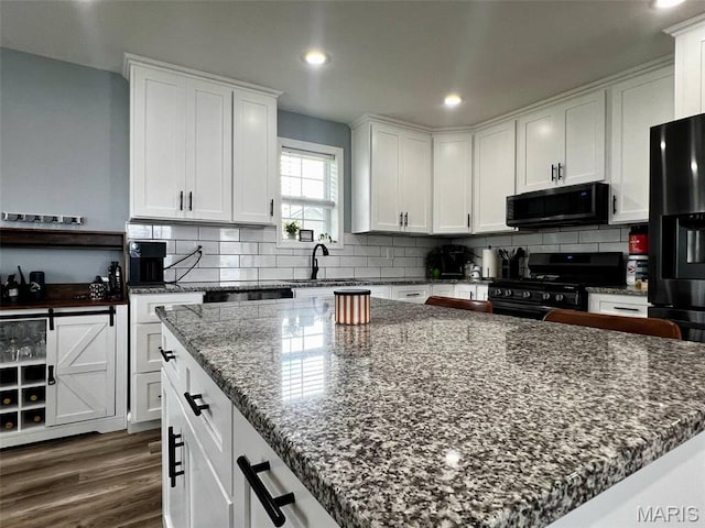 320 N Dickerson St, Palmyra, MO 63461 - kitchen featuring black appliances, white cabinetry, tasteful backsplash, dark stone counters, and recessed lighting