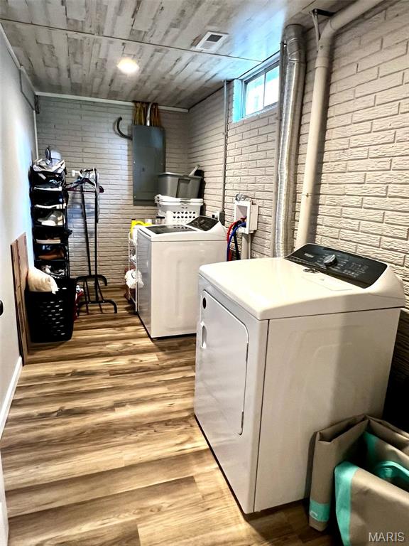 320 N Dickerson St, Palmyra, MO 63461 - laundry room with independent washer and dryer, brick wall, electric panel, and light wood finished floors