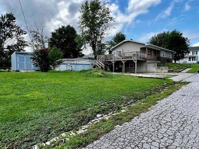 320 N Dickerson St, Palmyra, MO 63461 - view of green lawn featuring a wooden deck, a storage unit, an outdoor pool, and stairway