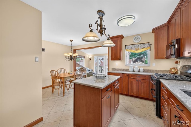 6580 Oleatha Ave, Saint Louis, MO 63139 - kitchen with black gas stove, light tile patterned floors, pendant lighting, a kitchen island, and a chandelier