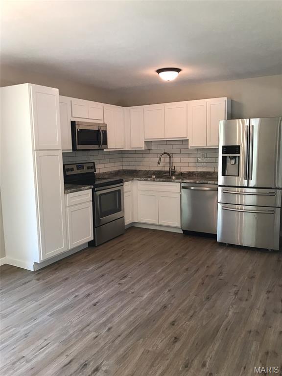 522 Judith Ann Pl, Fairview Heights, IL 62208 - kitchen featuring appliances with stainless steel finishes, dark countertops, dark wood-style flooring, and white cabinetry
