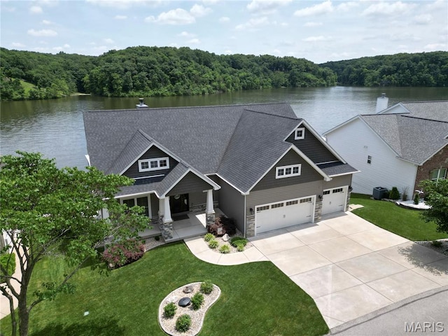 10234 Village Dr, Foristell, MO 63348 - craftsman-style house featuring a view of trees, covered porch, concrete driveway, and a water view