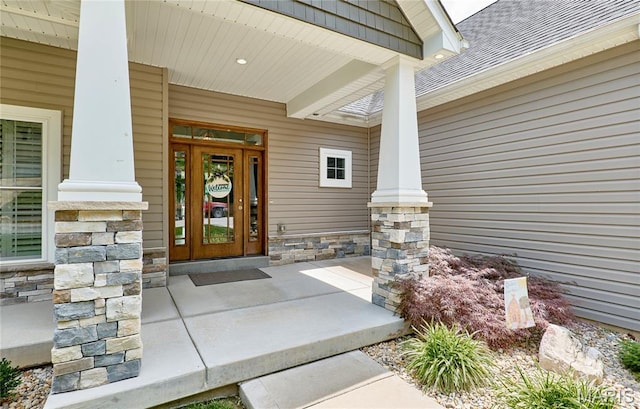 10234 Village Dr, Foristell, MO 63348 - doorway to property featuring stone siding, covered porch, and roof with shingles