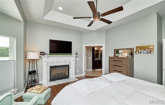 10234 Village Dr, Foristell, MO 63348 - bedroom featuring wood finished floors, a fireplace, a ceiling fan, recessed lighting, and a raised ceiling