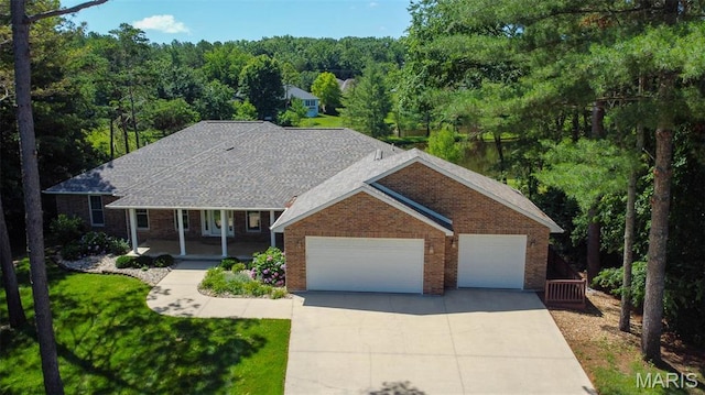 11782 Pine Forest Dr, Rolla, MO 65401 - view of front of home featuring driveway, brick siding, a garage, covered porch, and a front yard