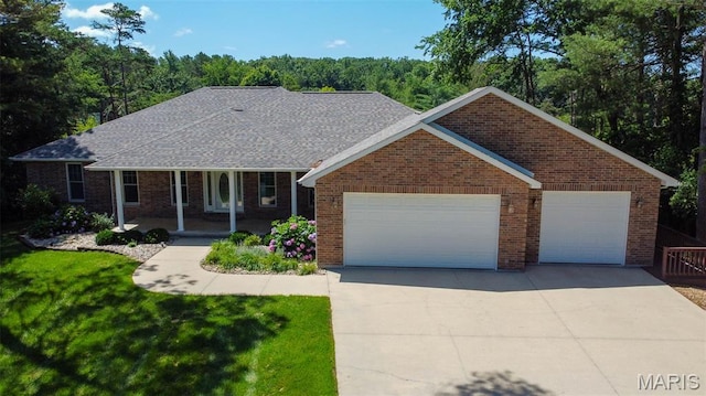 11782 Pine Forest Dr, Rolla, MO 65401 - view of front of property with concrete driveway, a garage, a front lawn, and brick siding
