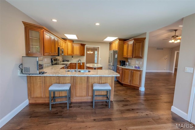 11782 Pine Forest Dr, Rolla, MO 65401 - kitchen featuring appliances with stainless steel finishes, a peninsula, dark wood finished floors, brown cabinets, and recessed lighting