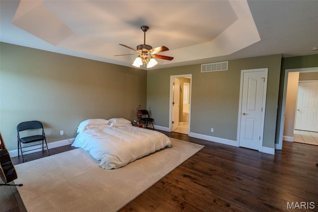 11782 Pine Forest Dr, Rolla, MO 65401 - bedroom featuring a tray ceiling, wood finished floors, a ceiling fan, and ensuite bath