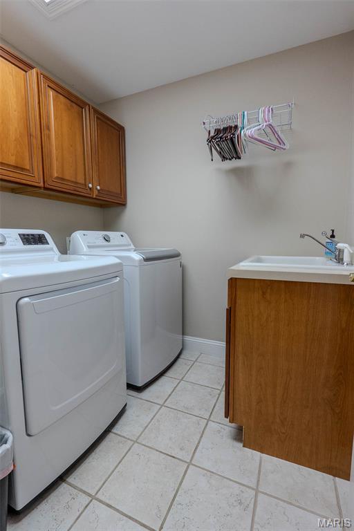 11782 Pine Forest Dr, Rolla, MO 65401 - laundry room featuring cabinet space, washing machine and clothes dryer, and light tile patterned flooring