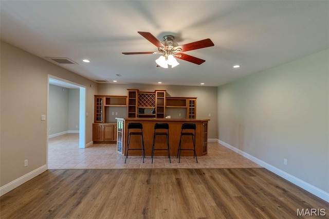 11782 Pine Forest Dr, Rolla, MO 65401 - kitchen with open shelves, a breakfast bar area, light wood-style floors, recessed lighting, and ceiling fan