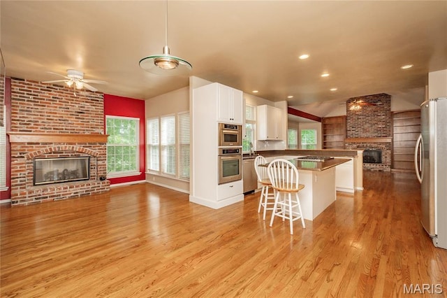 742 Arbor Ridge Ct, Ballwin, MO 63021 - kitchen with a brick fireplace, open floor plan, ceiling fan, stainless steel appliances, and light wood-style floors