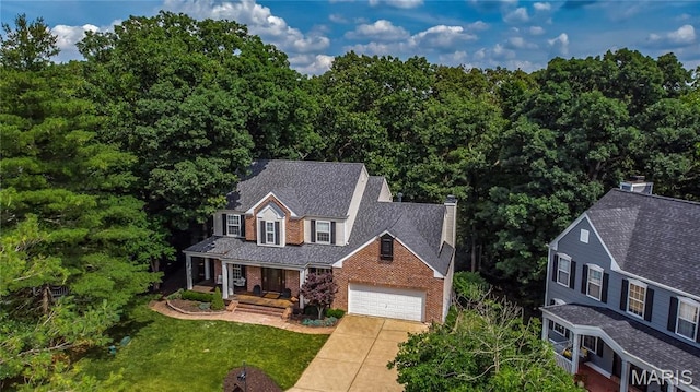 742 Arbor Ridge Ct, Ballwin, MO 63021 - view of front of property featuring a porch, driveway, a chimney, brick siding, and a front lawn