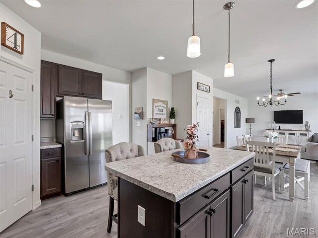 1673 Lake Meade Dr, Pacific, MO 63069 - kitchen with stainless steel refrigerator with ice dispenser, open floor plan, light wood finished floors, light countertops, and a breakfast bar
