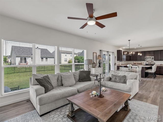 1673 Lake Meade Dr, Pacific, MO 63069 - living area featuring a chandelier, ceiling fan, and light wood-type flooring