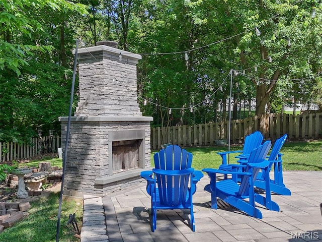 10 Renaud Pass, Ofallon, MO 63366 - fenced backyard with an outdoor stone fireplace and a patio