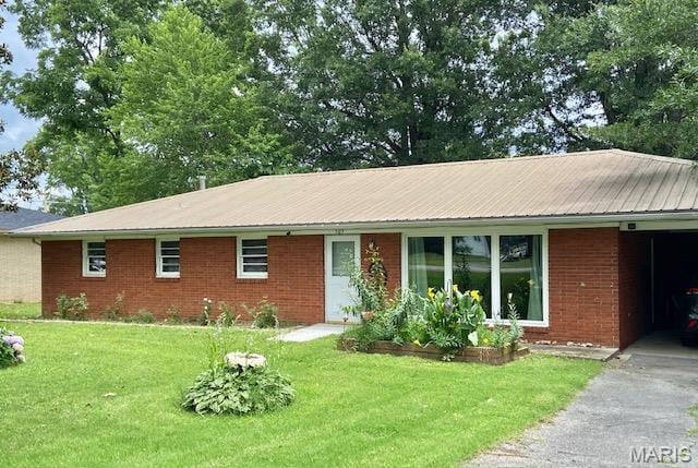 ranch-style home featuring a front yard, brick siding, and a garage