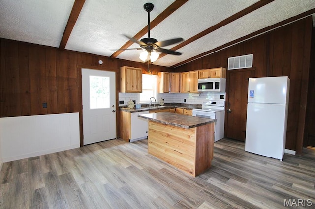 14525 Meadowlark Ln, Saint Genevieve, MO 63670 - kitchen with white appliances, wood walls, a center island, light wood-style floors, and dark countertops