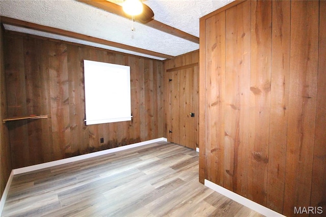 14525 Meadowlark Ln, Saint Genevieve, MO 63670 - spare room featuring wooden walls, wood finished floors, a textured ceiling, beamed ceiling, and ceiling fan