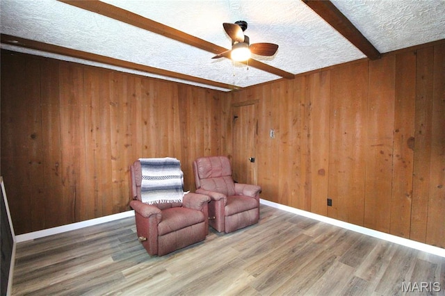 14525 Meadowlark Ln, Saint Genevieve, MO 63670 - living area featuring ceiling fan, wood finished floors, wooden walls, a textured ceiling, and beam ceiling