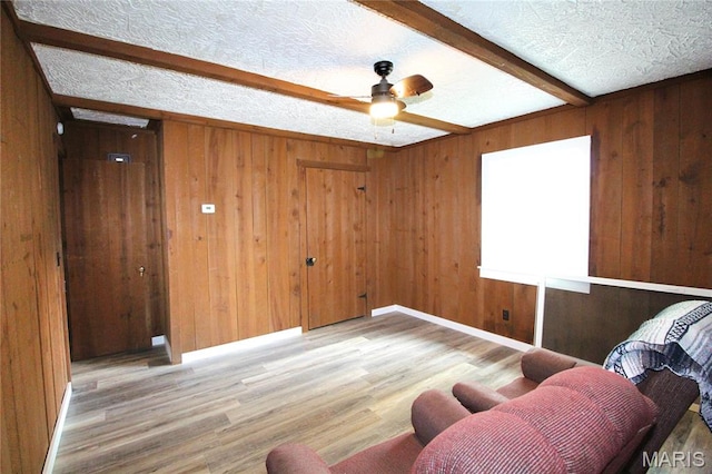 14525 Meadowlark Ln, Saint Genevieve, MO 63670 - living area with a ceiling fan, wood finished floors, wooden walls, beam ceiling, and a textured ceiling