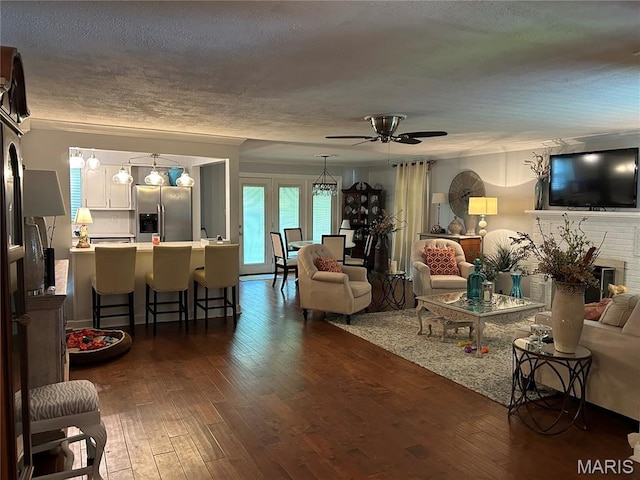 301 W Clipper St, Kennett, MO 63857 - living area with ceiling fan, dark wood-style floors, a textured ceiling, and a brick fireplace