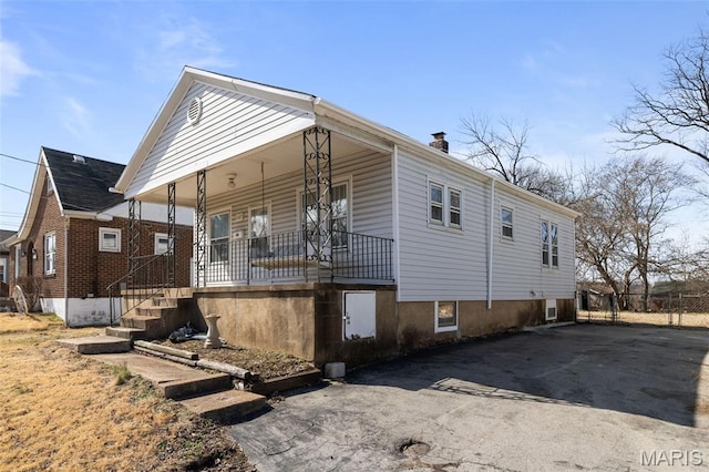 1307 Weleba Ave, Saint Louis, MO 63121 - view of property exterior with a porch, driveway, and a chimney