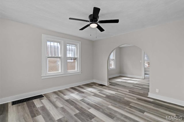 1307 Weleba Ave, Saint Louis, MO 63121 - unfurnished room with arched walkways, wood finished floors, and a ceiling fan