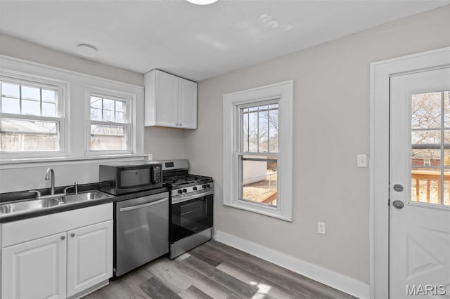 1307 Weleba Ave, Saint Louis, MO 63121 - kitchen featuring stainless steel appliances, plenty of natural light, and white cabinetry