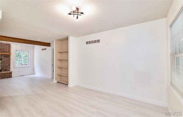 271 Westwood Trl, Foristell, MO 63348 - unfurnished living room featuring light wood finished floors, a textured ceiling, and a fireplace