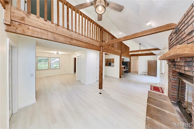 271 Westwood Trl, Foristell, MO 63348 - unfurnished living room featuring ceiling fan, high vaulted ceiling, a brick fireplace, wood finished floors, and a textured ceiling