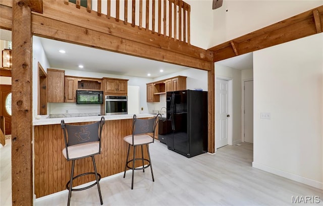 271 Westwood Trl, Foristell, MO 63348 - kitchen with black appliances, open shelves, a peninsula, light wood-type flooring, and a high ceiling