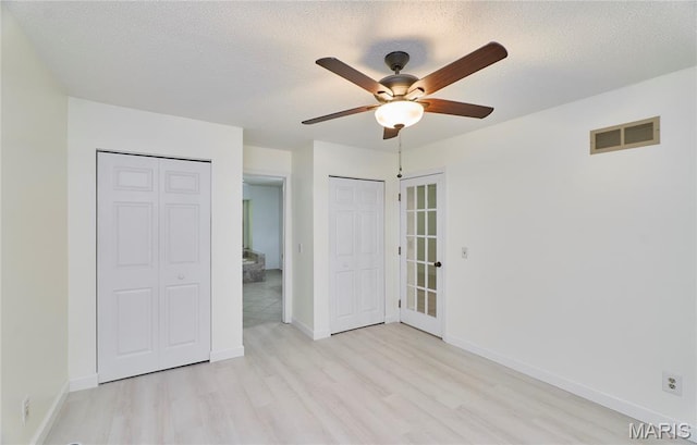 271 Westwood Trl, Foristell, MO 63348 - unfurnished bedroom with light wood finished floors, multiple closets, a textured ceiling, and ceiling fan