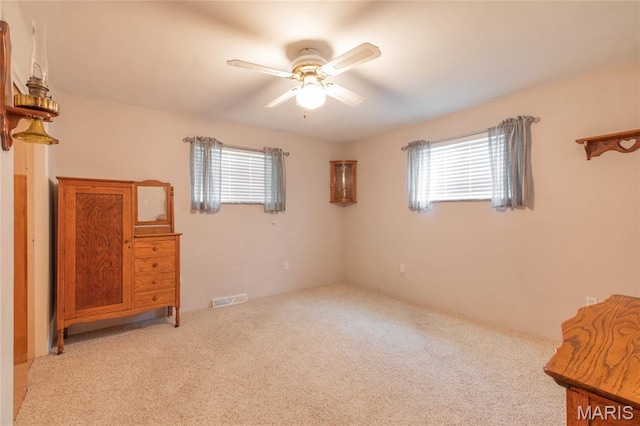 457 Maple Dr, Bethalto, IL 62010 - unfurnished bedroom with light colored carpet, multiple windows, and ceiling fan