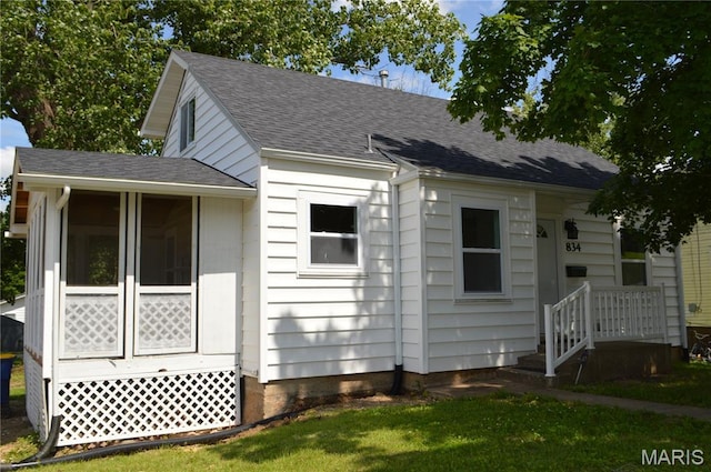 834 Vine St, Festus, MO 63028 - view of front of property with a shingled roof, a sunroom, and a front lawn