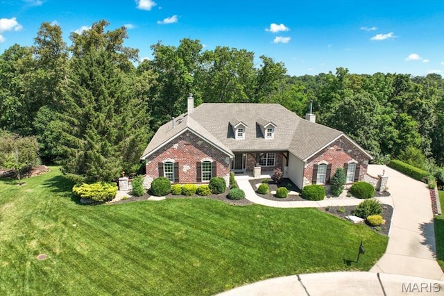 886 Arbor Chase Dr, Wildwood, MO 63021 - view of front of property featuring brick siding, a front yard, a chimney, and a forest view