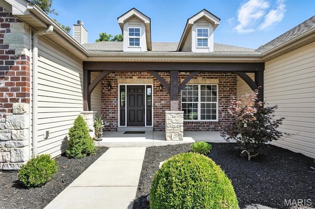 886 Arbor Chase Dr, Wildwood, MO 63021 - view of exterior entry with brick siding, a porch, a chimney, and roof with shingles