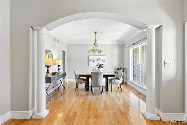 886 Arbor Chase Dr, Wildwood, MO 63021 - dining space with decorative columns, crown molding, light wood-style floors, arched walkways, and a chandelier
