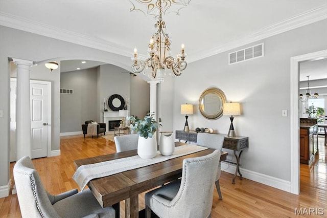 886 Arbor Chase Dr, Wildwood, MO 63021 - dining space with a chandelier, arched walkways, light wood finished floors, crown molding, and a fireplace