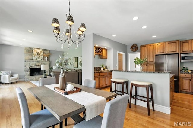 886 Arbor Chase Dr, Wildwood, MO 63021 - dining room featuring a chandelier, light wood-type flooring, recessed lighting, and a fireplace