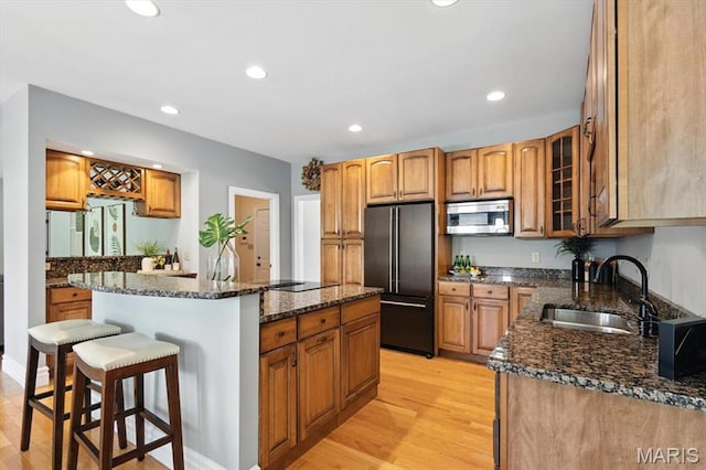 886 Arbor Chase Dr, Wildwood, MO 63021 - kitchen featuring high end fridge, stainless steel microwave, a kitchen bar, light wood-style flooring, and a center island