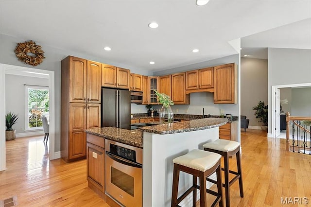 886 Arbor Chase Dr, Wildwood, MO 63021 - kitchen featuring stainless steel appliances, a kitchen breakfast bar, recessed lighting, glass insert cabinets, and light wood-style floors