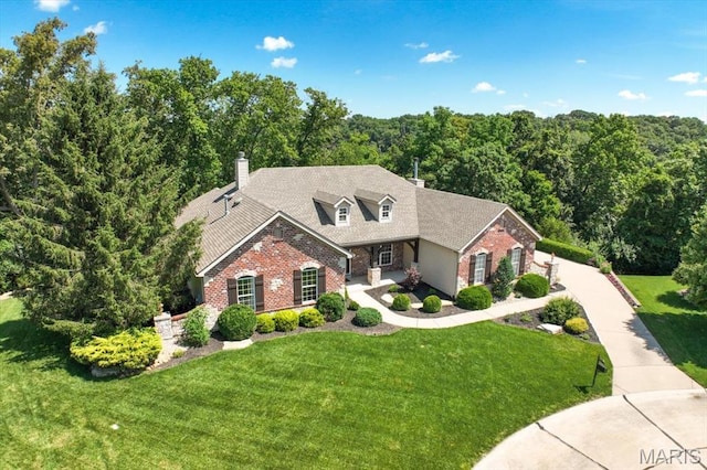 886 Arbor Chase Dr, Wildwood, MO 63021 - traditional-style house featuring brick siding, a front lawn, a wooded view, and a chimney