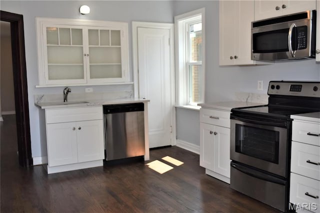 4521 Tholozan Ave, Saint Louis, MO 63116 - kitchen featuring appliances with stainless steel finishes, white cabinetry, glass insert cabinets, and dark wood finished floors