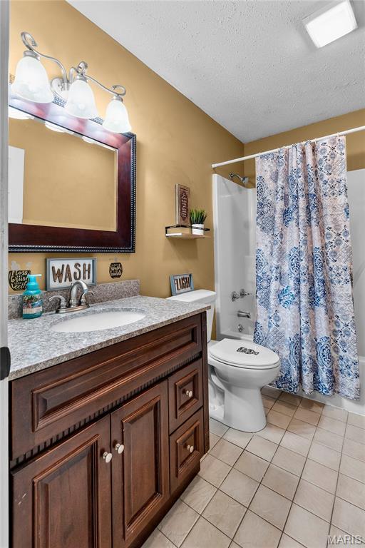 1133 Cypress Ct, Cape Girardeau, MO 63701 - full bathroom with tile patterned flooring, vanity, a textured ceiling, and shower / bath combo with shower curtain