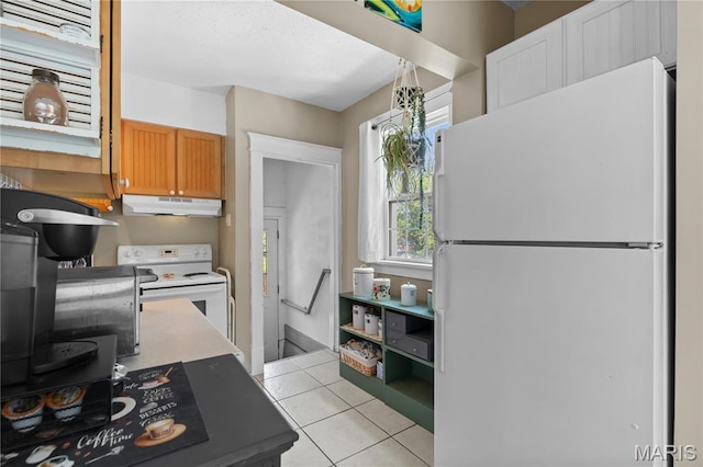 10225 Driver Ave, Overland, MO 63114 - kitchen featuring white appliances, under cabinet range hood, light tile patterned floors, light countertops, and brown cabinetry