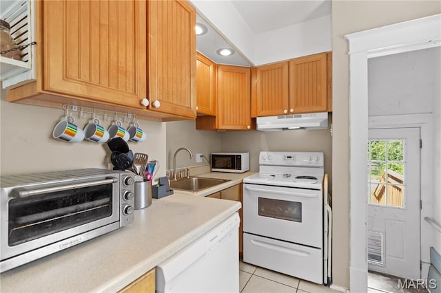 10225 Driver Ave, Overland, MO 63114 - kitchen with white appliances, under cabinet range hood, light countertops, light tile patterned floors, and recessed lighting