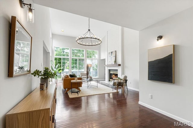938 Blase Ave, Saint Louis, MO 63131 - living room featuring wood finished floors, a chandelier, and a large fireplace